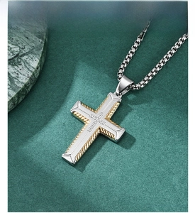 Detail of hip hop two-tone steel cross pendant with tire pattern and gold trim