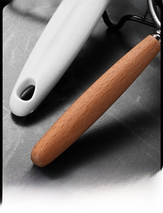 Detail of ergonomic smooth white and natural wood handles on stainless steel ice clips