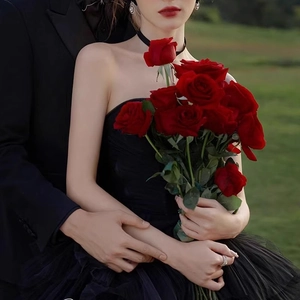 Romantic red velvet rose bouquet held by a woman in elegant black dress for home decor