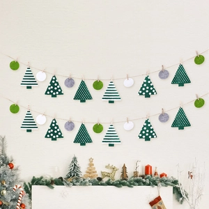 Weihnachts-Filzgirlande mit Tannen und Scheiben aufgehängt an einer weißen Wand
