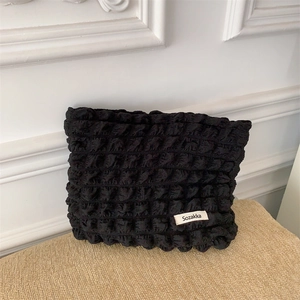 Detailed shot of black bubble textured fabric on canvas makeup bag with Sozakka label