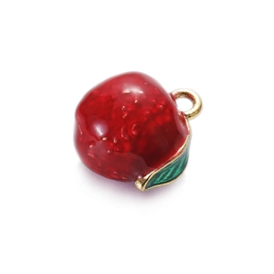 Detailed close-up of a red enamel apple charm with gold border and green leaf detail