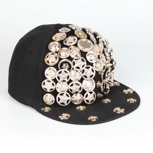 Close-up of black hip hop hat featuring gold star studs and Medusa relief buckles