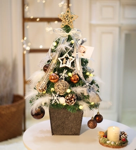 Mini Christmas tree with warm lights, white feathers and golden ornaments in grey felt pot