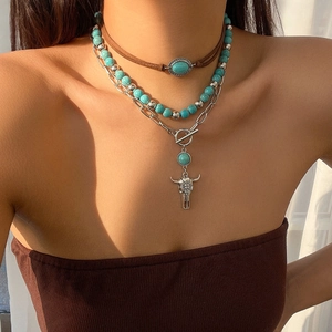 Detailed close-up of Bohemian layered necklace with turquoise beads and bull skull pendant