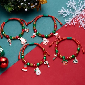 Detail of Christmas beaded bracelets with Santa and snowman charms on festive background