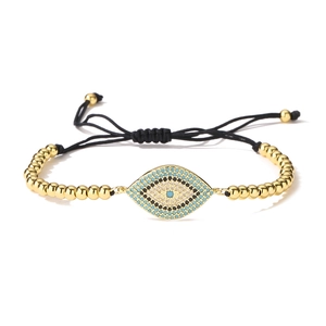Detail of 18K gold plated evil eye bracelet with blue zircon and black braided cord