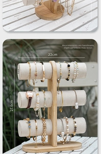 Detailed view of a 3-tier bamboo jewelry stand with grey velvet bars for bracelets