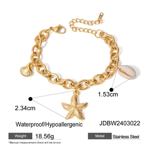 Detail view of gold stainless steel ocean bracelet with starfish and shell charms
