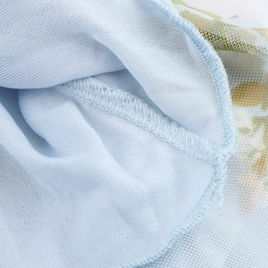 Détail macro du tissu en maille bleu clair avec couture surjetée bleue précise
