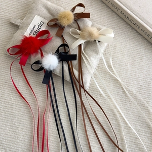 Ballet-style hair clips with plush pom-poms, bows, and long ribbons in four colors