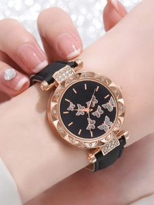 Close-up of a women's rose gold watch with butterfly dial and black leather strap