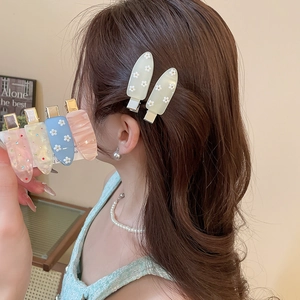 Detailed macro view of candy-colored hair clips featuring floral prints and rhinestone accents