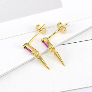 Macro view of gold punk cone earrings featuring vibrant fuchsia rectangular zircons