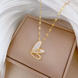 Close-up of double heart necklace with gold finish, mother of pearl and zircon details