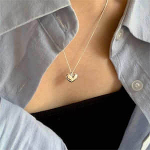 Close-up of a minimalist 925 sterling silver heart pendant necklace on a model