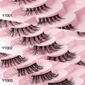 Three styles of natural thick black half-lash extensions on a pink display tray