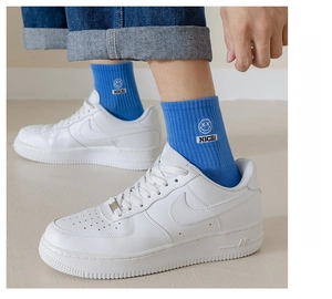 Detail of bright blue smiley cotton socks worn with sneakers for a sporty style