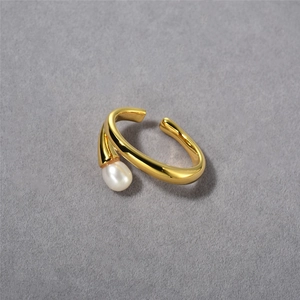 Detail of elegant gold-plated brass ring with a lustrous white pearl on dark background