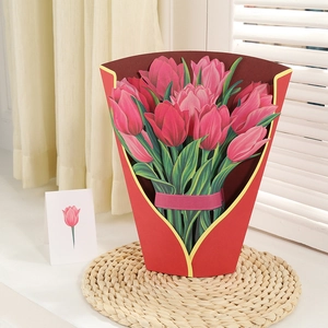 Detail of 3D pop-up pink tulip flower bouquet card with red wrap and gift ribbon