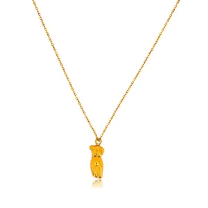 Macro shot of 18K gold plated female torso pendant with polished cross chain