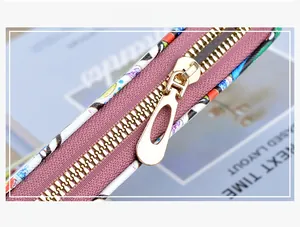 Detail shot of the durable golden metal zipper and colorful printed faux leather fabric