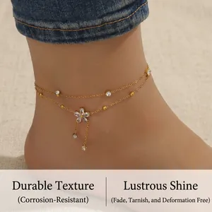 Detail of gold-plated double-layer anklet with zircon flower and dangling chain tassels