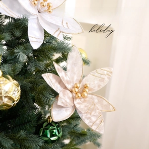 Elegant cream white Christmas artificial flower with gold accents on a festive tree