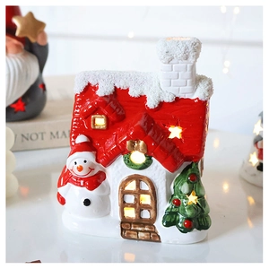 Macro shot of white ceramic LED house with red roof and snowman Christmas decoration