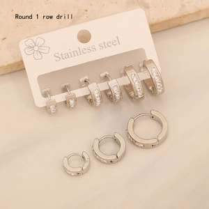 Close-up of three sizes of silver stainless steel hoop earrings with crystal pavé setting