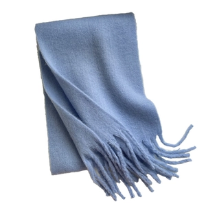 Light blue chunky knit winter scarf with long tassels on a clean white background