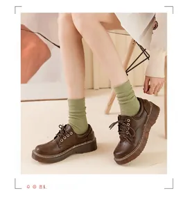 Detail view of dark brown platform oxford shoes with classic laces and matte leather