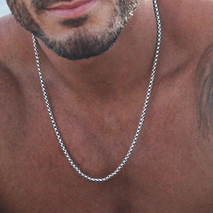 Close-up of a silver stainless steel round box chain worn by a male model