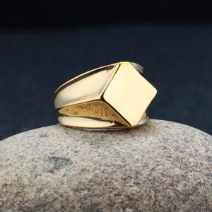 Dettaglio di un anello a sigillo quadrato placcato oro su una base in pietra naturale