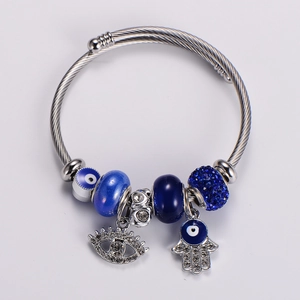 Detail of twisted silver bracelet with blue evil eye beads and Hamsa hand charm