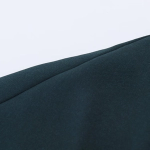 Dettaglio ravvicinato della cucitura precisa sul tessuto twill verde scuro