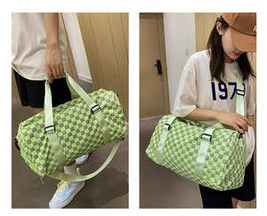 Detail view of large capacity green plaid travel duffel bag with handles and shoulder strap