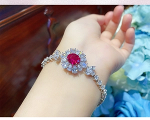 Dettaglio del bracciale a girasole con tormalina rossa e cristalli bianchi su polso donna