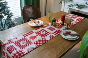Close-up of Christmas table runner featuring red and white plaid with tree patterns