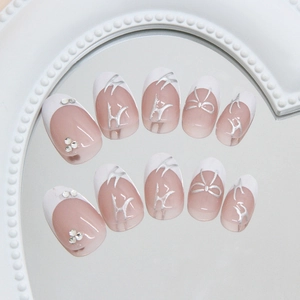French press-on nails with silver metallic bows and rhinestones on nude pink base