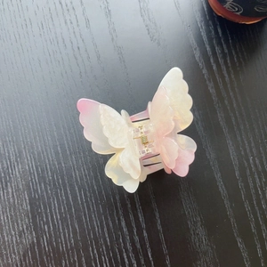 Detail of double-layer butterfly hair claw clip with pink gradient and glitter finish