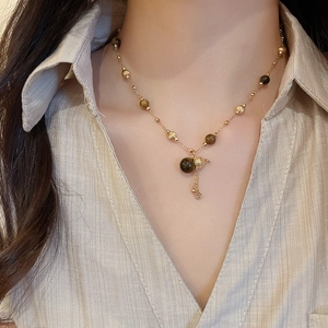 Macro shot of 18K gold plated tiger eye necklace featuring gourd and coin charms
