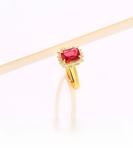 Macro shot of an adjustable gold ring featuring a rectangle red gem and side diamonds