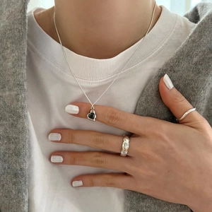 Minimalist S925 silver necklace featuring a black heart-shaped pendant on a female model