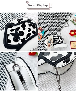 Detailed view of cowboy hat shaped crossbody bag with cow print and star detail