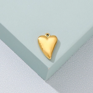 Polished gold heart pendant made of titanium steel on a light blue geometric background