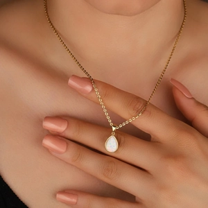 French minimalist teardrop opal necklace in gold plating worn by a model