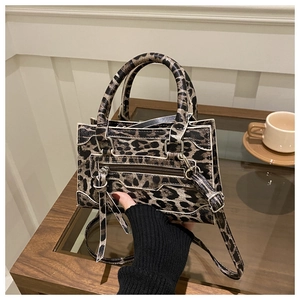 Dettaglio della texture leopardata e delle fibbie metalliche sulla borsa a tracolla vintage