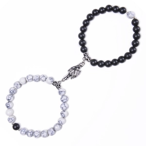 Detail of natural stone magnetic couple bracelets with a handshake-shaped clasp