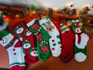 Detailed view of plush Christmas socks with reindeer and tree patterns in festive decor